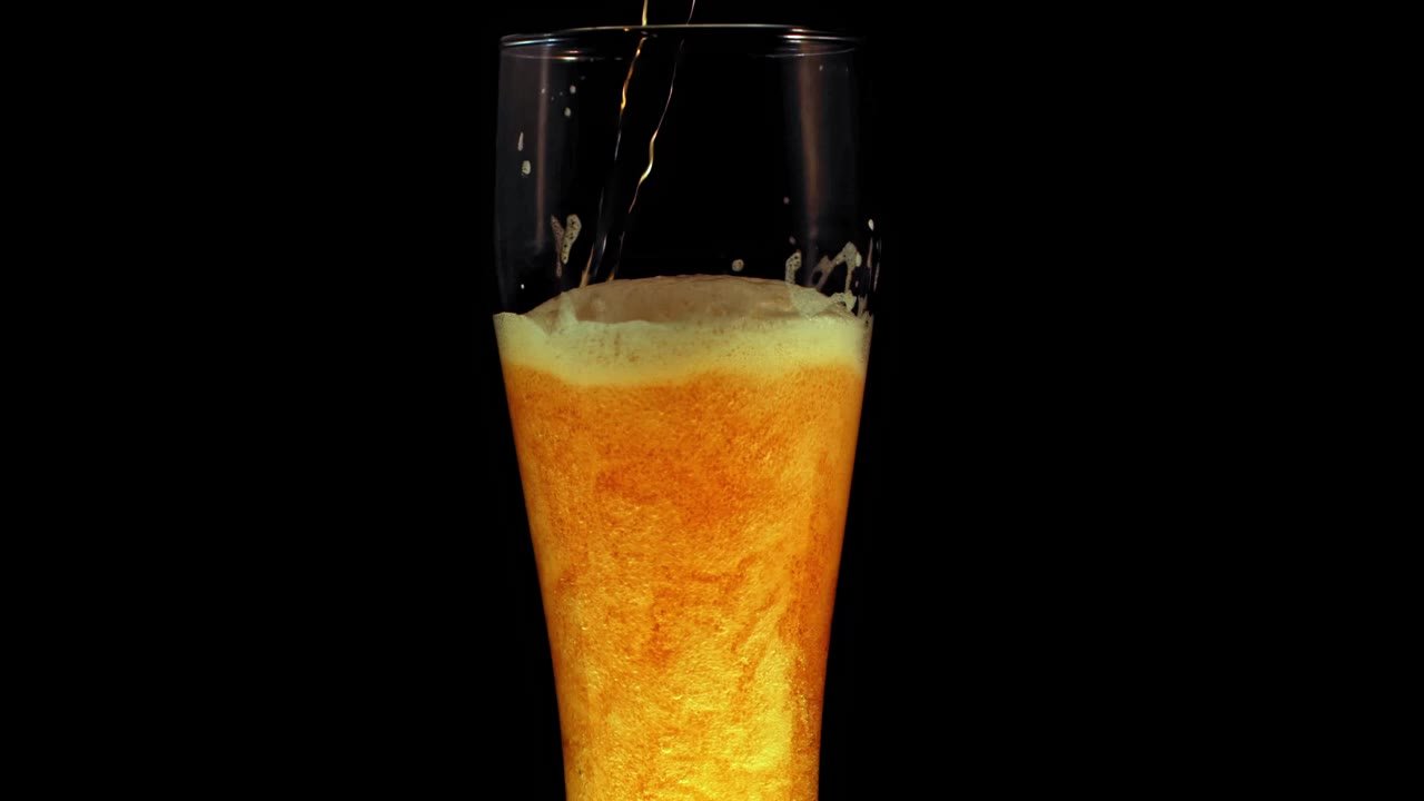Un grand verre de bière ambrée, à la mousse fine.